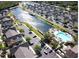 Aerial view showcasing a community with a lake, pool, and numerous houses at 2280 San Vital Dr # 105, Kissimmee, FL 34741