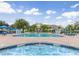 Community pool and spa area with lounge chairs and umbrellas at 2280 San Vital Dr # 105, Kissimmee, FL 34741