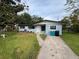 Light blue house with a green lawn and driveway at 4587 Elmira Pl, Orlando, FL 32811