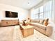 Open living room with light-grey couch, wood coffee table, and large TV at 742 Longboat Dr, Davenport, FL 33896