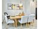 Modern dining room with light wood table and six light-grey cushioned chairs at 742 Longboat Dr, Davenport, FL 33896