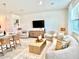 Open concept living room with curved couch, wood coffee table, and large TV at 742 Longboat Dr, Davenport, FL 33896