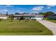 Single-story house with a spacious yard, driveway, and basketball hoop at 1395 Emerald Dr, Kissimmee, FL 34744
