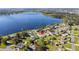 House on a lakefront property with a large yard and surrounding houses at 1395 Emerald Dr, Kissimmee, FL 34744