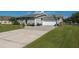 Gray house with white garage door and basketball hoop. Landscaped lawn at 1395 Emerald Dr, Kissimmee, FL 34744