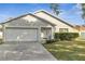 Two-story house with white garage door and landscaping at 613 Delaware Ave, Saint Cloud, FL 34769