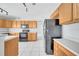 Kitchen features wood cabinets, black appliances, and a tile floor at 613 Delaware Ave, Saint Cloud, FL 34769