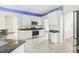 Modern kitchen with white cabinets, granite countertops, and stainless steel appliances at 805 Via Bianca Dr, Davenport, FL 33896