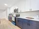 Modern kitchen with stainless steel appliances and two-toned blue and white cabinets at 135 S Chandler Ave, Deland, FL 32724