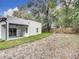 Home's backyard with a grassy area and tree line at 135 S Chandler Ave, Deland, FL 32724