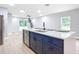 Kitchen island with white quartz countertop and blue cabinetry, plus stainless steel dishwasher at 135 S Chandler Ave, Deland, FL 32724
