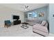 Bright living room featuring a sectional sofa, coffee table, and a large TV at 8932 Stinger Dr, Davenport, FL 33896