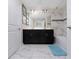 Bathroom with double vanity, marble tile, and a large mirror at 8932 Stinger Dr, Davenport, FL 33896