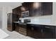 Modern kitchen with dark cabinetry and stainless steel appliances at 8932 Stinger Dr, Davenport, FL 33896