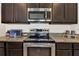 Stainless steel range and microwave in a kitchen with dark wood cabinets at 353 Summershore Dr, Auburndale, FL 33823