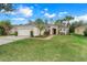 Two-car garage, light beige exterior, and landscaped front yard at 3838 Gulf Shore Cir, Kissimmee, FL 34746