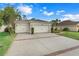 Two-car garage, light beige exterior, and landscaped front yard at 3838 Gulf Shore Cir, Kissimmee, FL 34746