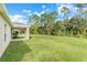 Large backyard with grassy area and covered patio at 3838 Gulf Shore Cir, Kissimmee, FL 34746