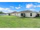 Backyard view of home with large grassy area at 3838 Gulf Shore Cir, Kissimmee, FL 34746