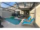 Private screened pool with lounge chairs and a grill at 4295 Paragraph Dr, Kissimmee, FL 34746