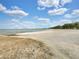 Scenic sandy beach with calm lake waters under a blue sky at 4321 Rummell Rd, St Cloud, FL 34769
