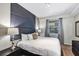 Main bedroom with king bed, gray accent wall and en-suite bathroom access at 4751 Clock Tower Dr # 107, Kissimmee, FL 34746