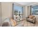 Bright living room with two comfy armchairs, a stylish console table, and large windows at 4751 Clock Tower Dr # 107, Kissimmee, FL 34746
