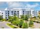 Building exterior, featuring a modern design, ample parking and landscaping at 4751 Clock Tower Dr # 107, Kissimmee, FL 34746