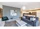 Open living room, featuring a stylish couch, accent chair, and a view of the kitchen at 4751 Clock Tower Dr # 107, Kissimmee, FL 34746
