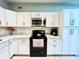 Modern kitchen with white cabinets, stainless steel appliances, and marble countertops at 5312 Goddard Ave, Orlando, FL 32810