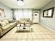 Spacious living room featuring light beige sofas and large windows at 5312 Goddard Ave, Orlando, FL 32810