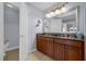 Double vanity bathroom with granite countertops and large mirror at 7662 Whisper Way # 402, Reunion, FL 34747