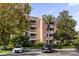 Three-story building with multiple units, ample parking, and landscaping at 7662 Whisper Way # 402, Reunion, FL 34747