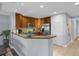 L-shaped kitchen with granite countertops and wood cabinets at 7662 Whisper Way # 402, Reunion, FL 34747