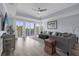 Spacious living room with hardwood floors, large windows, and access to a balcony at 7662 Whisper Way # 402, Reunion, FL 34747