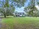 White ranch home with gray roof and red front door, nestled in a spacious yard at 965 Keen Rd, Frostproof, FL 33843