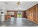 Spacious living room with wood walls, tile floors, and sliding glass doors leading to the backyard at 965 Keen Rd, Frostproof, FL 33843