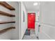 Laundry room with washer, dryer, shelving, and a bright red door at 965 Keen Rd, Frostproof, FL 33843