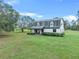 White ranch home with gray roof and red front door, nestled in a spacious yard at 965 Keen Rd, Frostproof, FL 33843