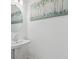 Small powder room with pedestal sink and round mirror at 3550 Davenport Creek Ct, Kissimmee, FL 34746