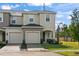 Two-story townhome with a tan exterior, two-car garage and landscaping at 3550 Davenport Creek Ct, Kissimmee, FL 34746