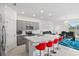 Modern kitchen with gray cabinets, white countertops, and red barstools at 3550 Davenport Creek Ct, Kissimmee, FL 34746