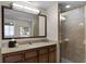 Bathroom with granite vanity, large mirror, and walk-in shower at 12527 Floridays Resort Dr # E-103, Orlando, FL 32821