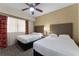 Two twin beds in a well-lit bedroom with ceiling fan at 12527 Floridays Resort Dr # E-103, Orlando, FL 32821