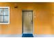 Exterior condo entrance with a tan wall and brown door at 12527 Floridays Resort Dr # E-103, Orlando, FL 32821
