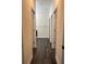 Long hallway with light walls, dark flooring, and doors to bedrooms and bathrooms at 221 Elm Ct, Poinciana, FL 34759