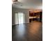 Open living room with vinyl flooring, access to the kitchen, and a sliding glass door at 221 Elm Ct, Poinciana, FL 34759