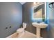 Small bathroom with a pedestal sink and toilet; dark grey walls at 5249 Villa Rosa Ave, St Cloud, FL 34771