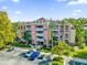 Aerial view of the building, highlighting its proximity to parking and surrounding landscape at 7650 Whisper Way # 203, Reunion, FL 34747