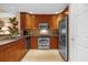 Well-equipped kitchen featuring wood cabinets and stainless steel appliances at 7650 Whisper Way # 203, Reunion, FL 34747